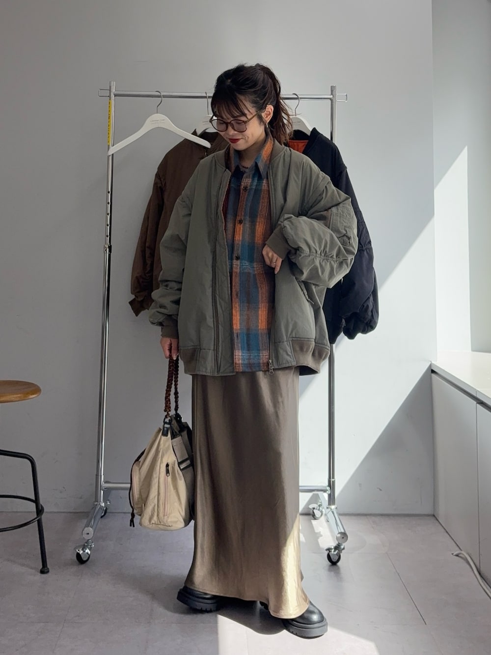 オレンジ系のシャツ/ブラウス、グリーン系のスカート、グリーン系のMA-1を着用したレディースの秋コーディネートの2枚目の写真