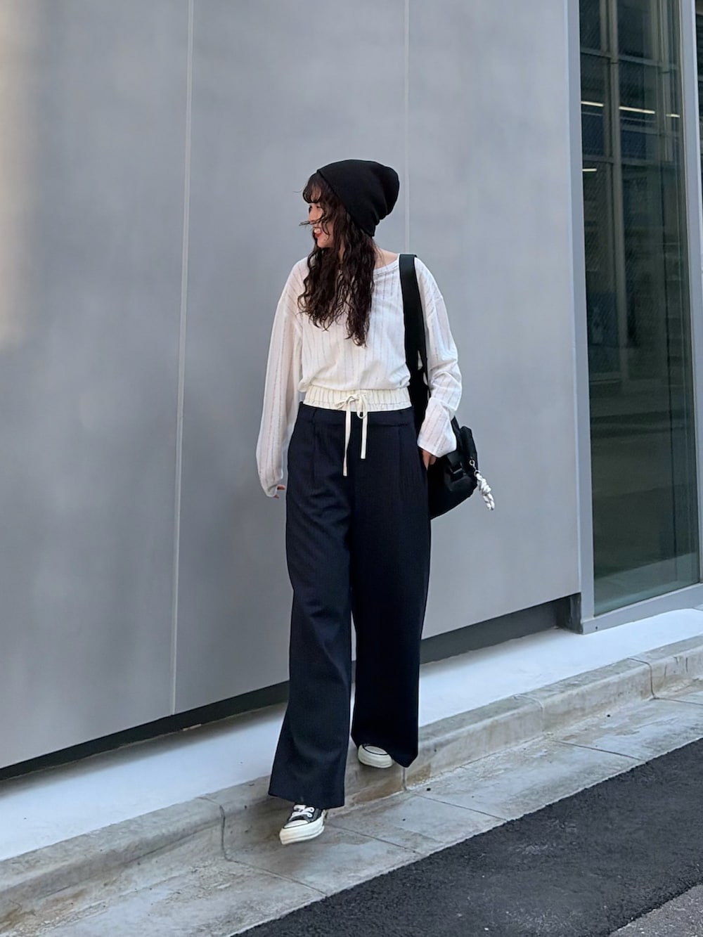 ホワイト系のTシャツ/カットソー、ブラック系のスラックス、ブラック系のニットキャップ/ビーニーを着用したレディースの春コーディネートの2枚目の写真