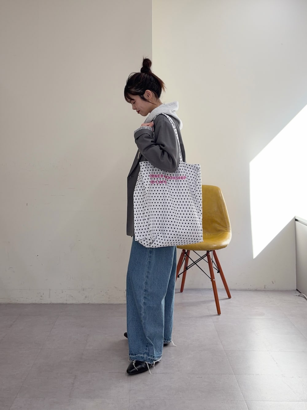 グレー系のパーカー、ブルー系のデニムパンツ、ブラック系のパンプスを着用したレディースの冬コーディネートの2枚目の写真