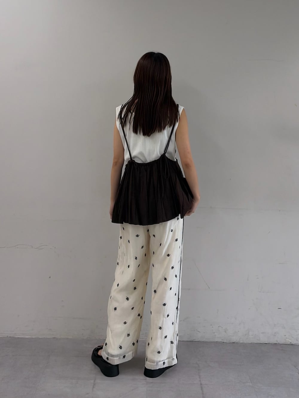 ホワイト系のその他パンツ、ブラック系のサンダル、ブラウン系のシャツ/ブラウスを着用したレディースの夏コーディネートの3枚目の写真
