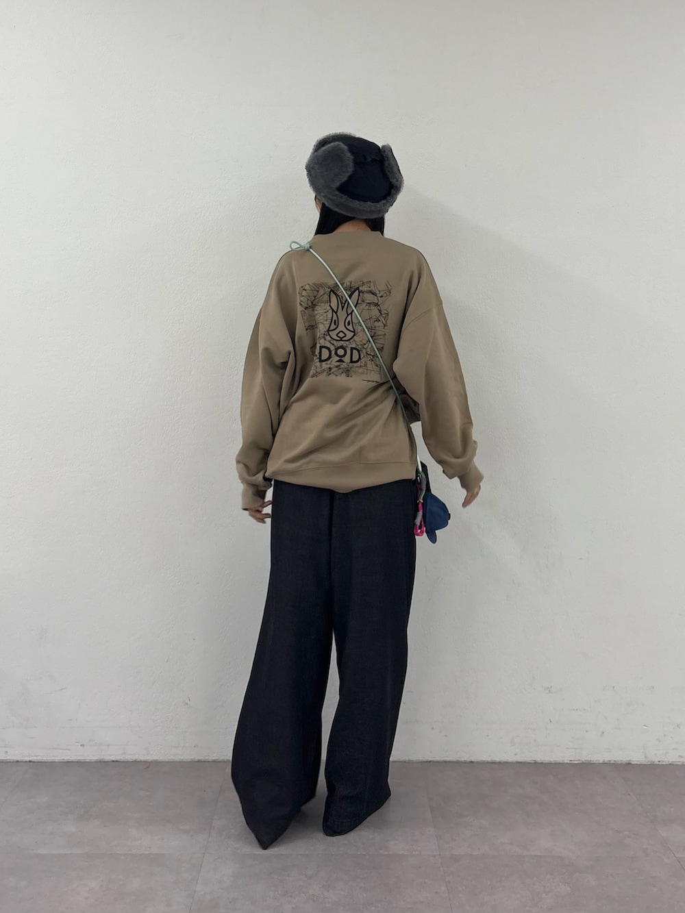 ベージュ系のスウェット、ブラック系のトートバッグ、ブラック系のデニムパンツを着用したレディースの秋コーディネートの3枚目の写真