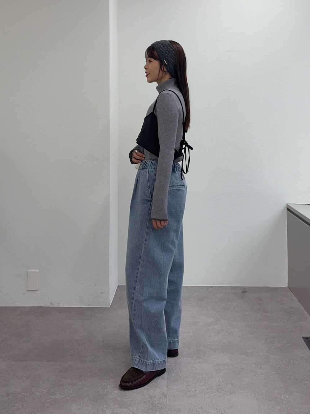 ブルー系のデニムパンツ、レッド系のローファー、グレー系のワンピースを着用したレディースの冬コーディネートの2枚目の写真