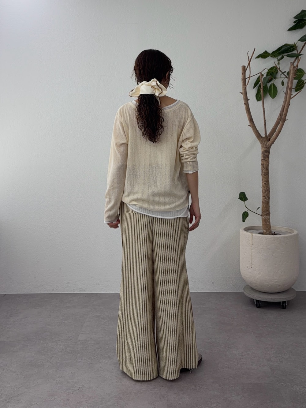 イエロー系のカーディガン/ボレロ、ベージュ系のその他パンツ、ホワイト系のシュシュを着用したレディースの春コーディネートの3枚目の写真