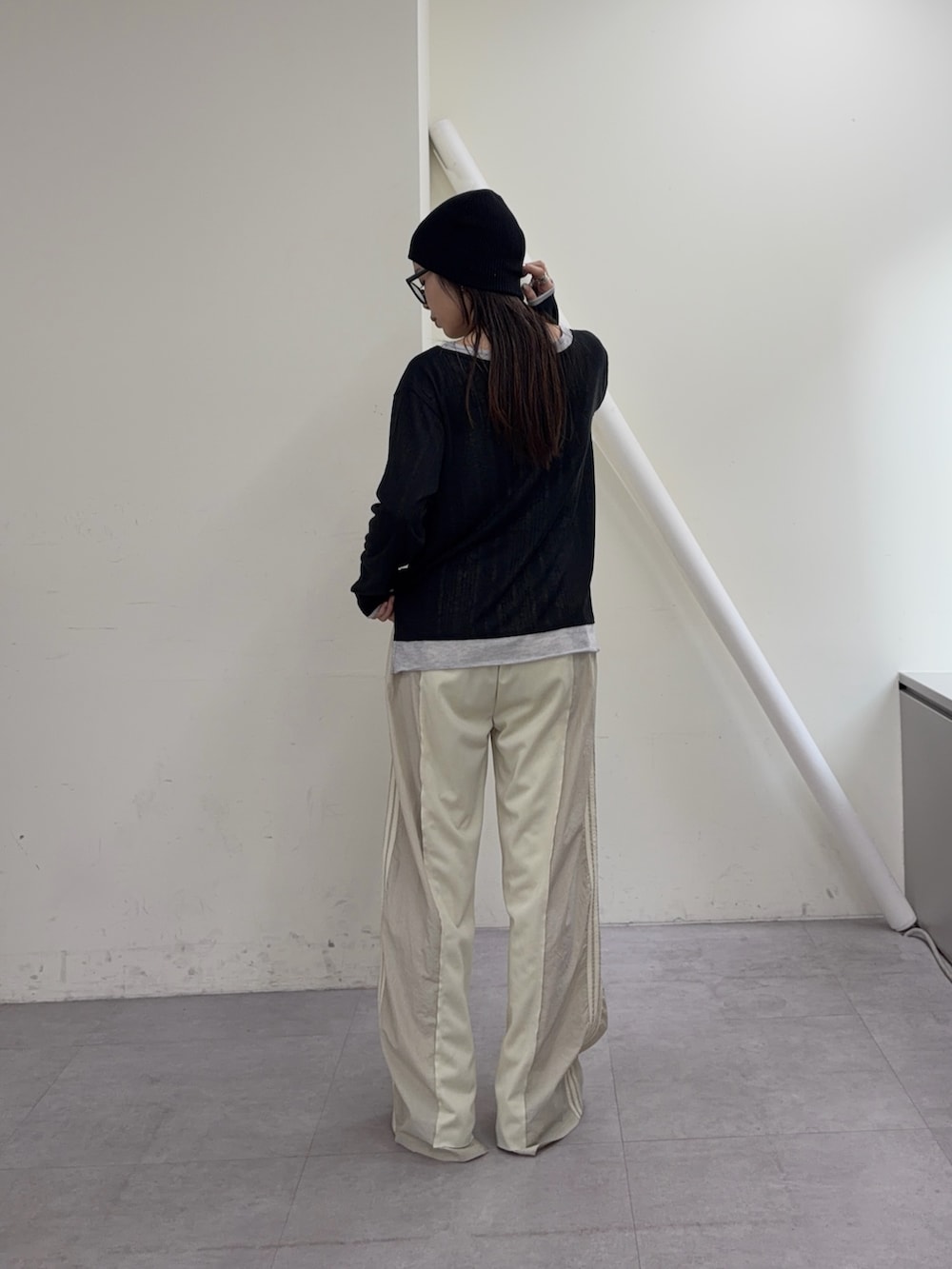 ブラック系のカーディガン/ボレロ、ホワイト系のスウェットパンツ、ブラック系のローファーを着用したレディースの冬コーディネートの3枚目の写真