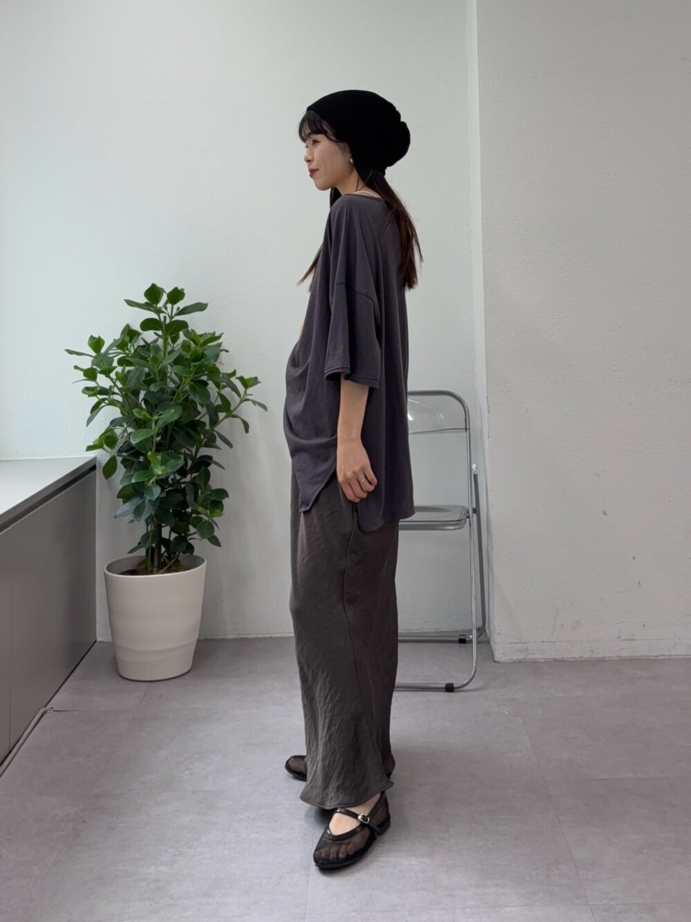 グレー系のTシャツ/カットソー、グレー系のスカート、ブラック系のパンプスを着用したレディースの夏コーディネートの2枚目の写真