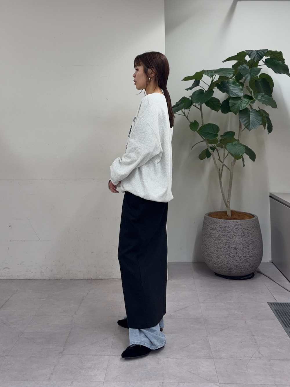 ブラック系のスカート、ブルー系のデニムパンツ、ブラック系のパンプスを着用したレディースの夏コーディネートの2枚目の写真