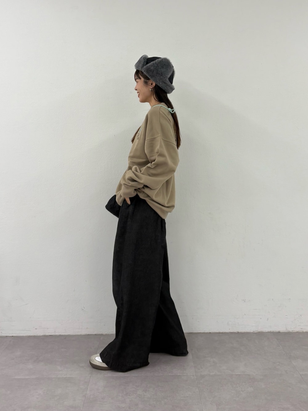 ベージュ系のスウェット、ブラック系のトートバッグ、ブラック系のデニムパンツを着用したレディースの秋コーディネートの2枚目の写真