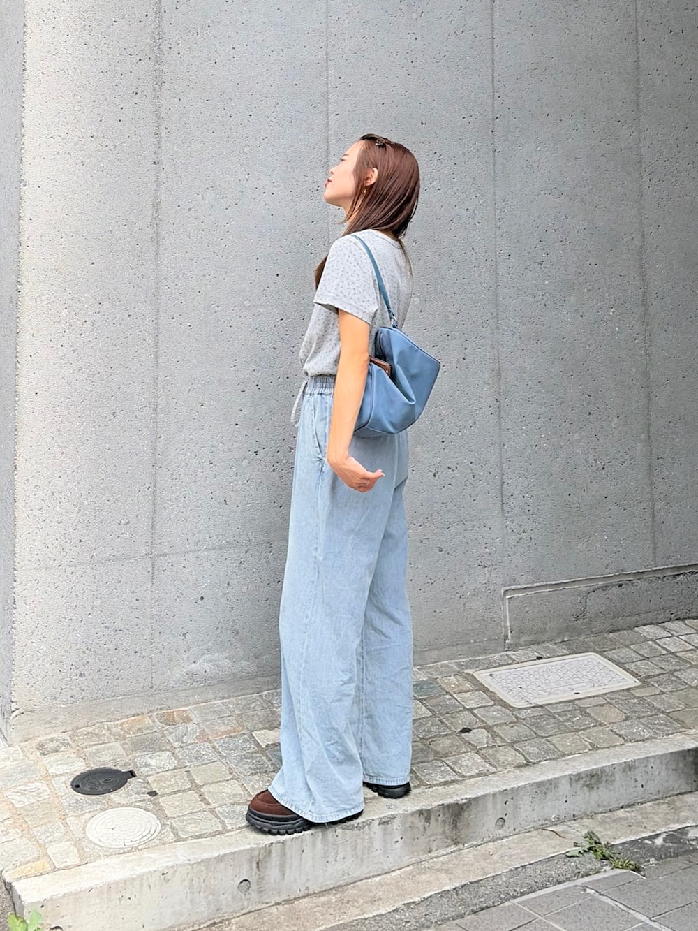 ブルー系のデニムパンツ、グレー系のTシャツ/カットソーを着用したレディースの夏コーディネートの2枚目の写真