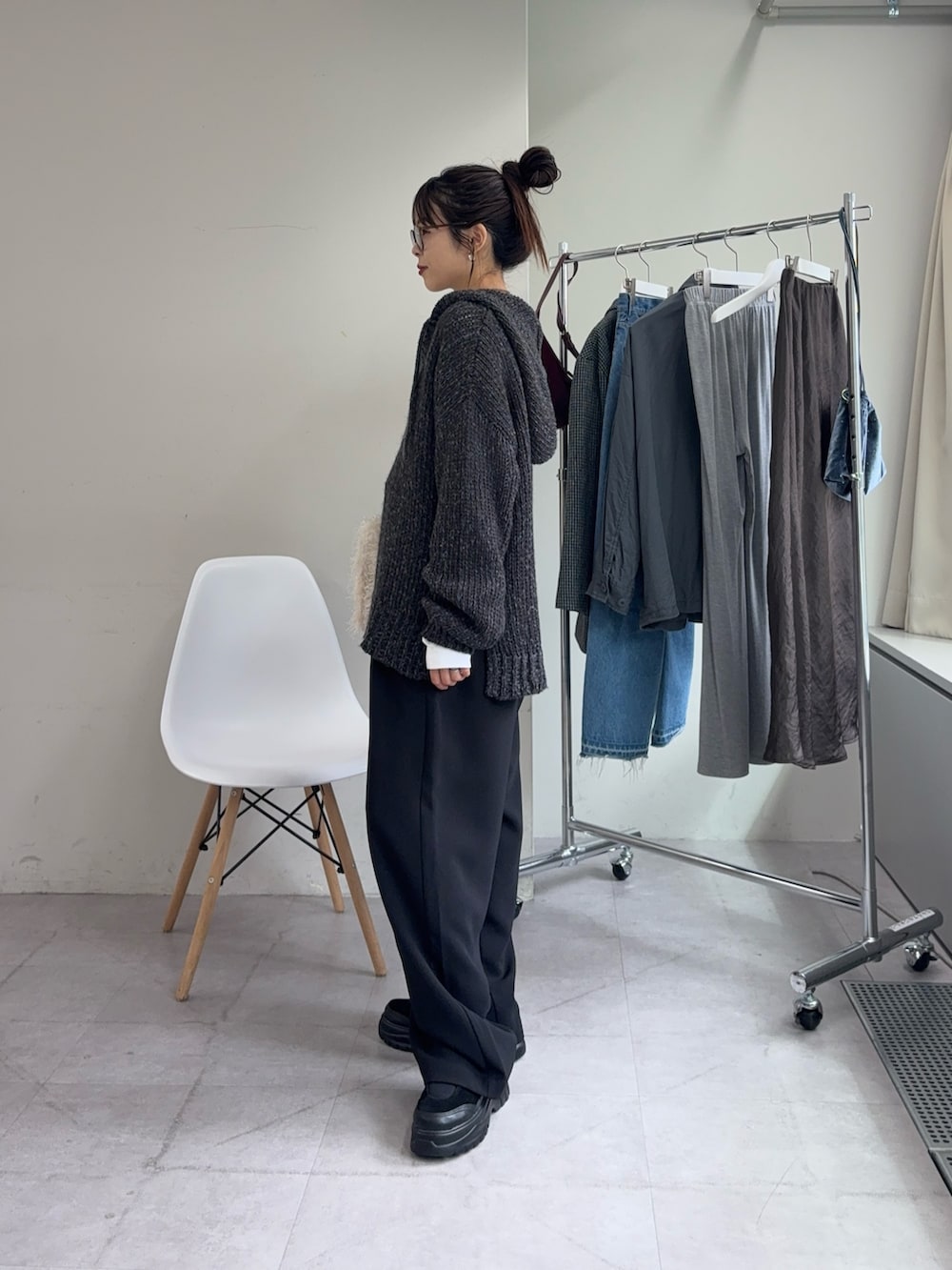 ホワイト系のTシャツ/カットソー、グレー系のニット/セーター、ブラック系のスラックスを着用したレディースの秋コーディネートの2枚目の写真