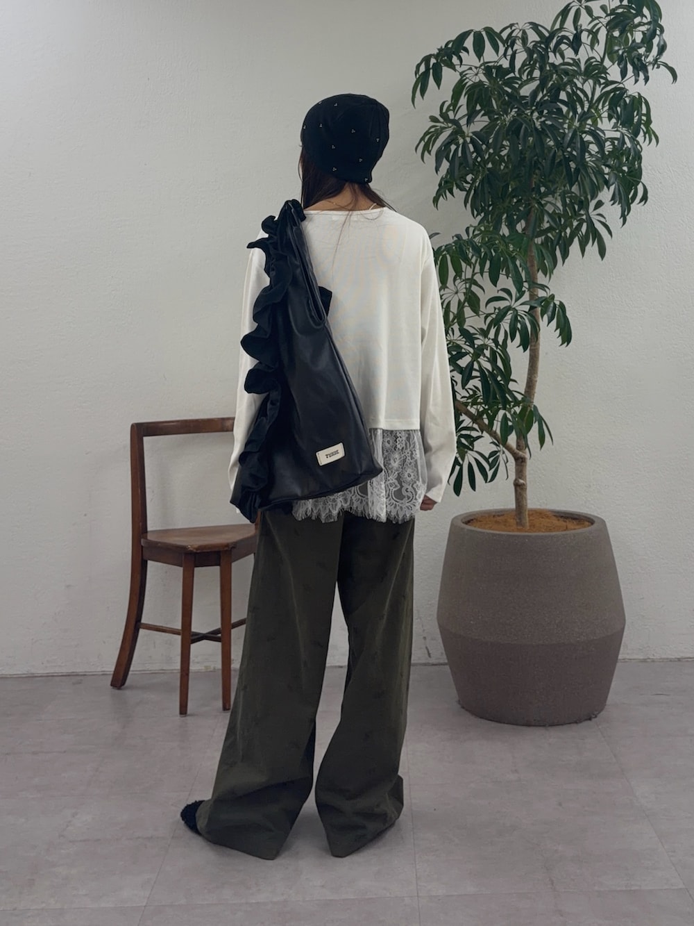 グリーン系のチノパンツ、ブラック系のその他シューズ、ブラック系のトートバッグを着用したレディースの秋コーディネートの3枚目の写真