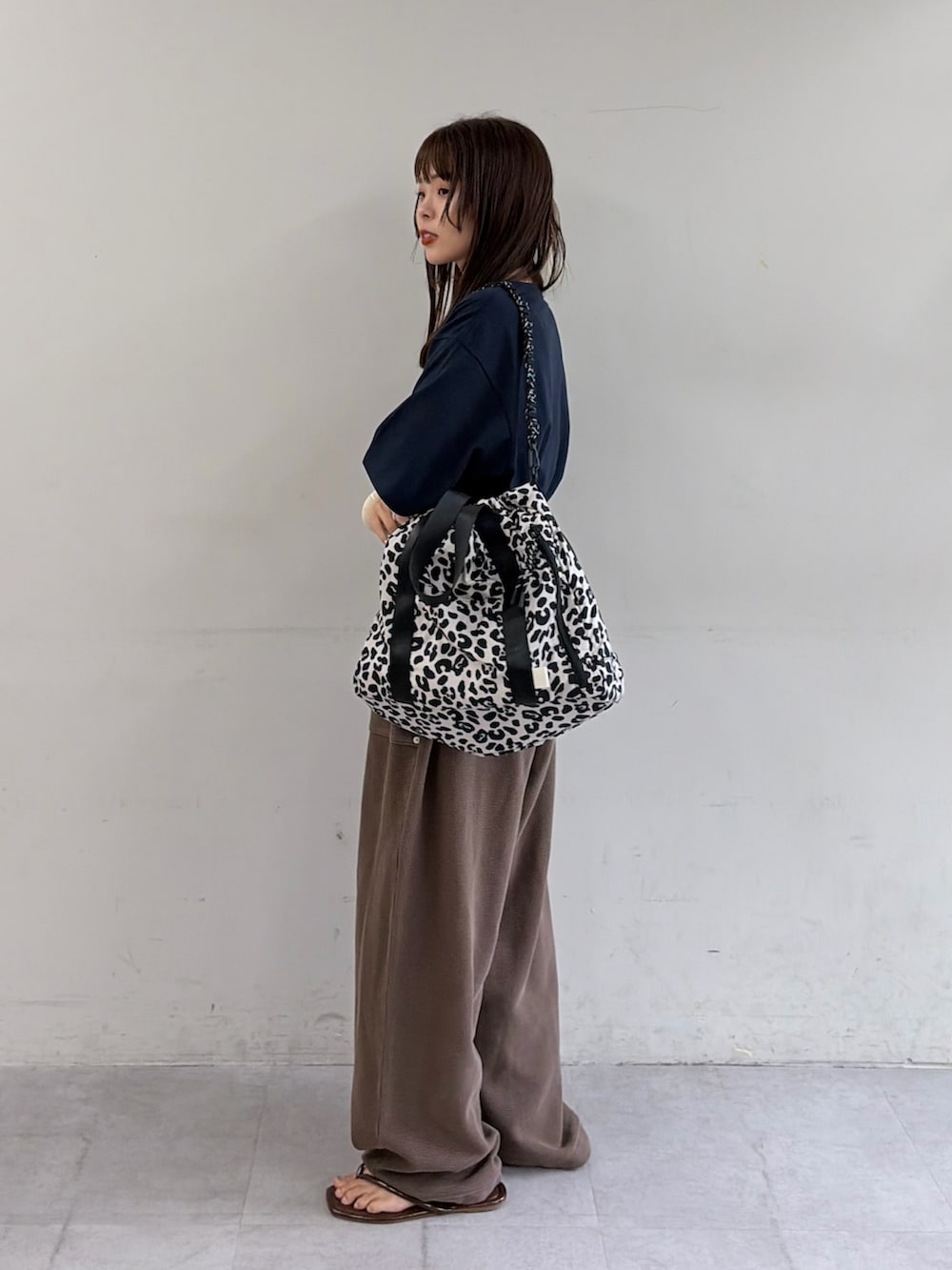 ブルー系のTシャツ/カットソー、ブラウン系のスウェットパンツ、ホワイト系のショルダーバッグを着用したレディースの夏コーディネートの2枚目の写真
