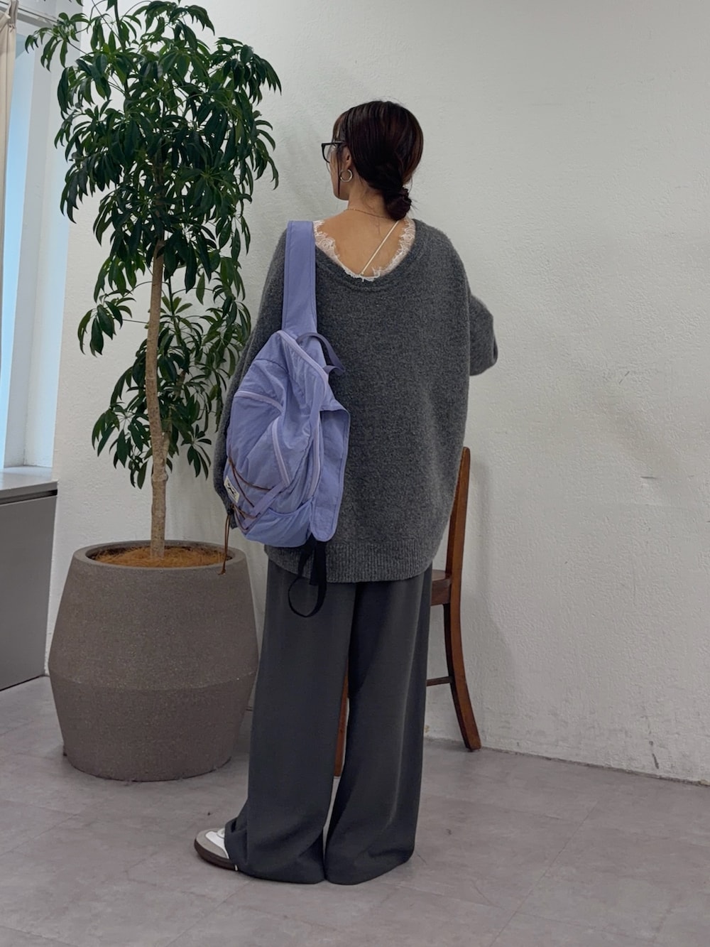 グレー系のニット/セーター、パープル系のバックパック/リュック、グレー系のスラックスを着用したレディースの秋コーディネートの3枚目の写真