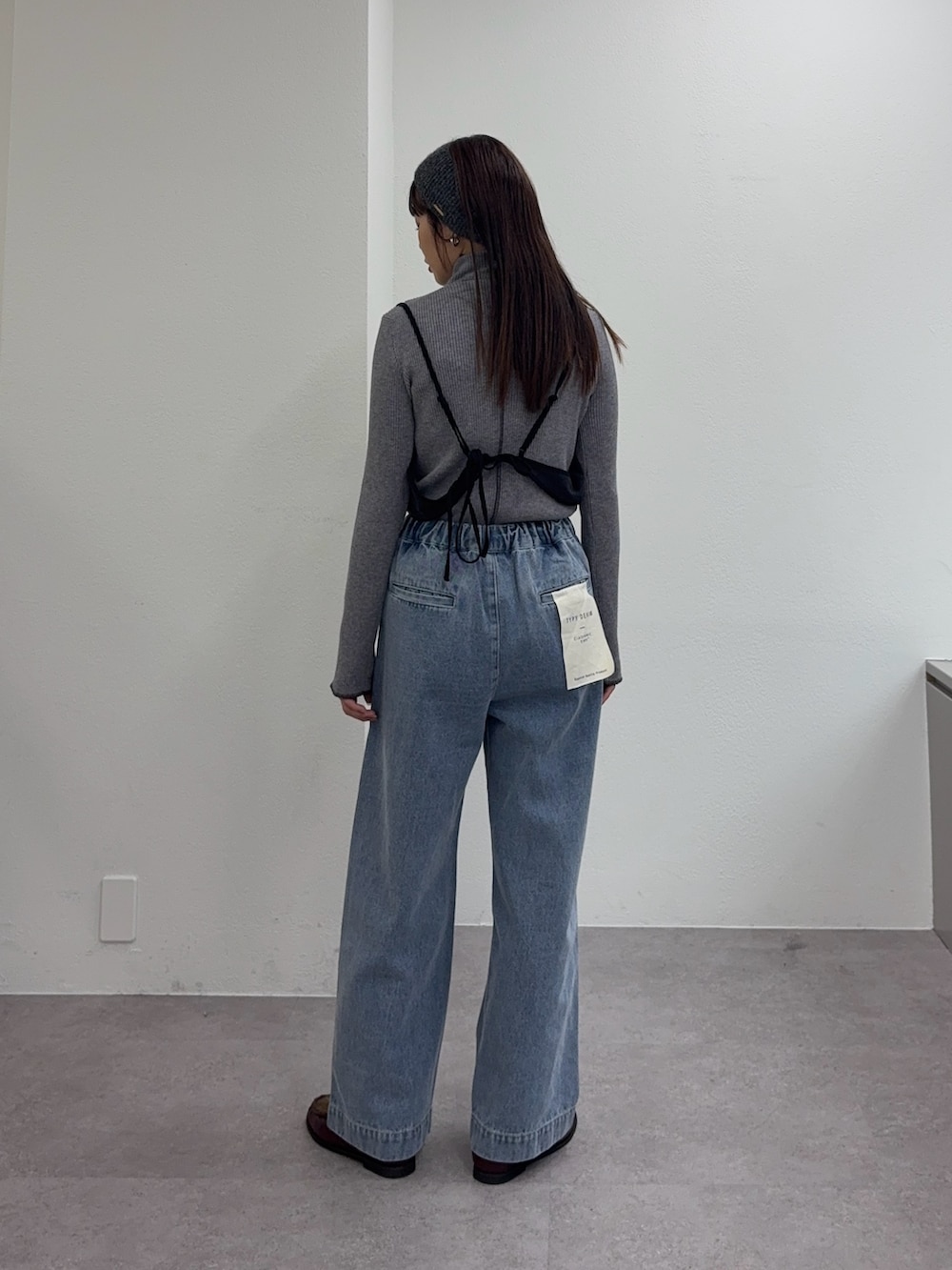 ブルー系のデニムパンツ、レッド系のローファー、グレー系のワンピースを着用したレディースの冬コーディネートの3枚目の写真