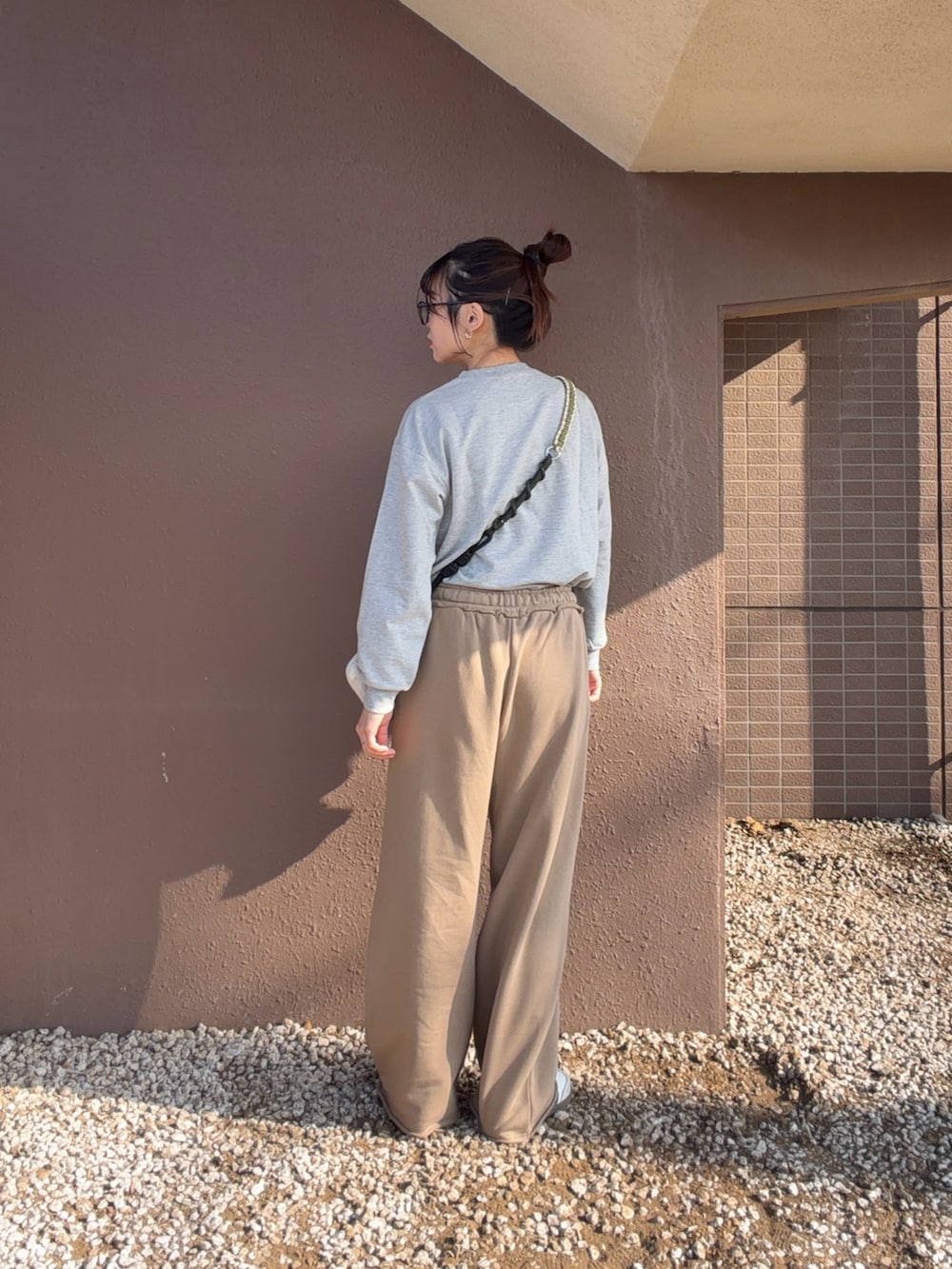 グレー系のTシャツ/カットソー、ベージュ系のスウェットパンツを着用したレディースの冬コーディネートの3枚目の写真