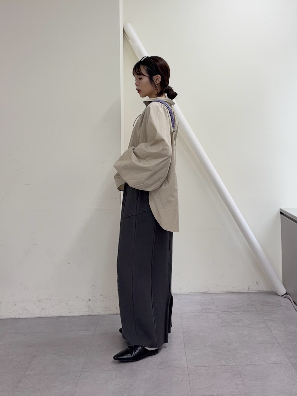 ベージュ系のシャツ/ブラウス、グレー系のスカート、ブラック系のパンプスを着用したレディースの冬コーディネートの2枚目の写真