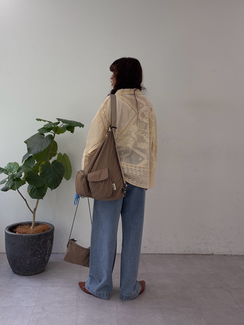 イエロー系のシャツ/ブラウス、ブルー系のデニムパンツを着用したレディースの春コーディネートの3枚目の写真