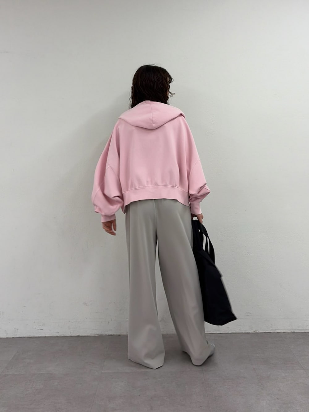 ピンク系のパーカー、シルバー系のパンプス、ブラック系のショルダーバッグを着用したレディースの春コーディネートの3枚目の写真