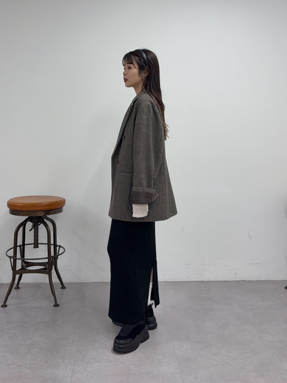 ホワイト系のTシャツ/カットソー、ブラウン系のテーラードジャケット、ブラック系のスカートを着用したレディースの秋コーディネートの2枚目の写真