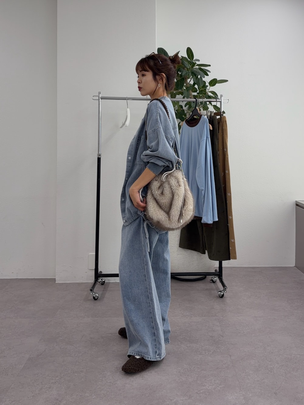 ブルー系のデニムパンツ、ベージュ系のトートバッグ、ブルー系のシャツ/ブラウスを着用したレディースの秋コーディネートの2枚目の写真