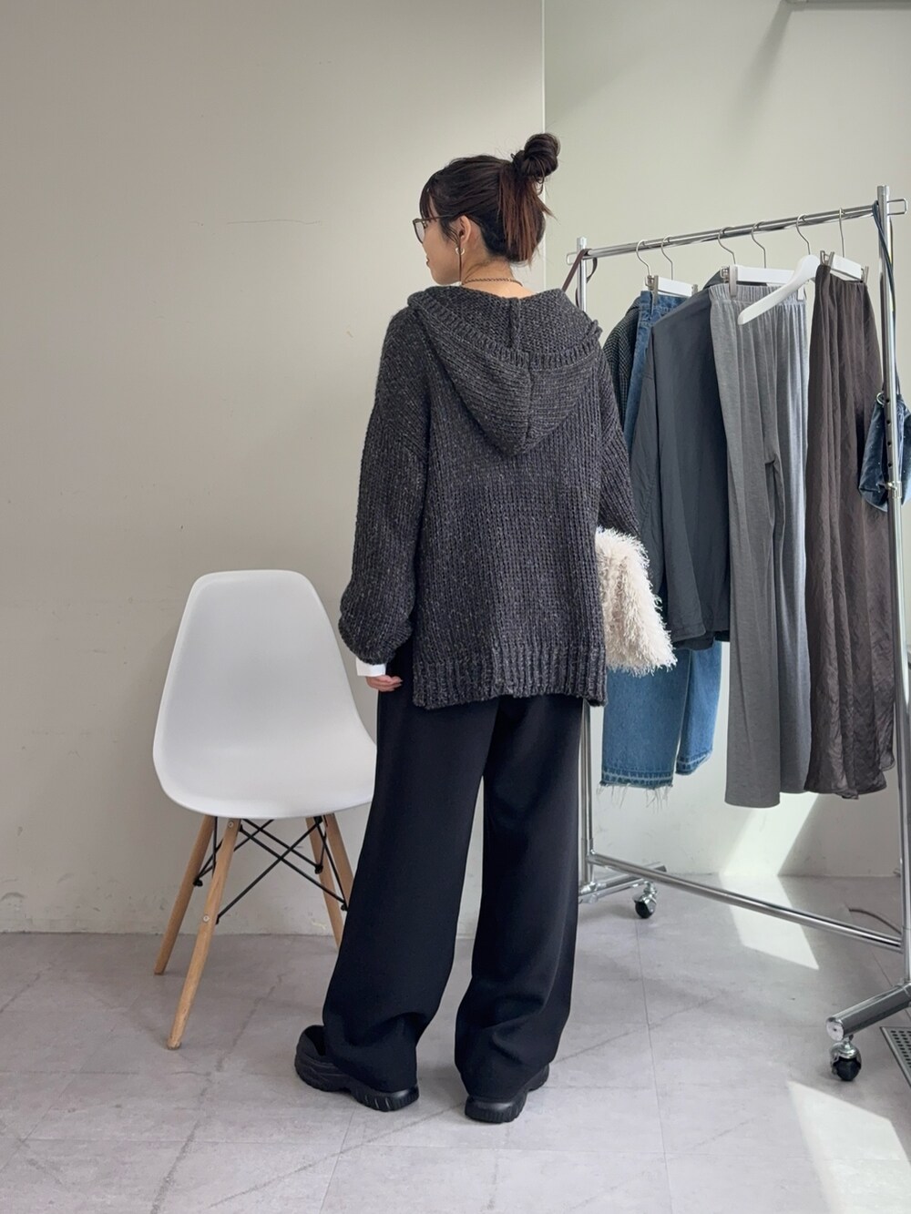 ホワイト系のTシャツ/カットソー、グレー系のニット/セーター、ブラック系のスラックスを着用したレディースの秋コーディネートの3枚目の写真