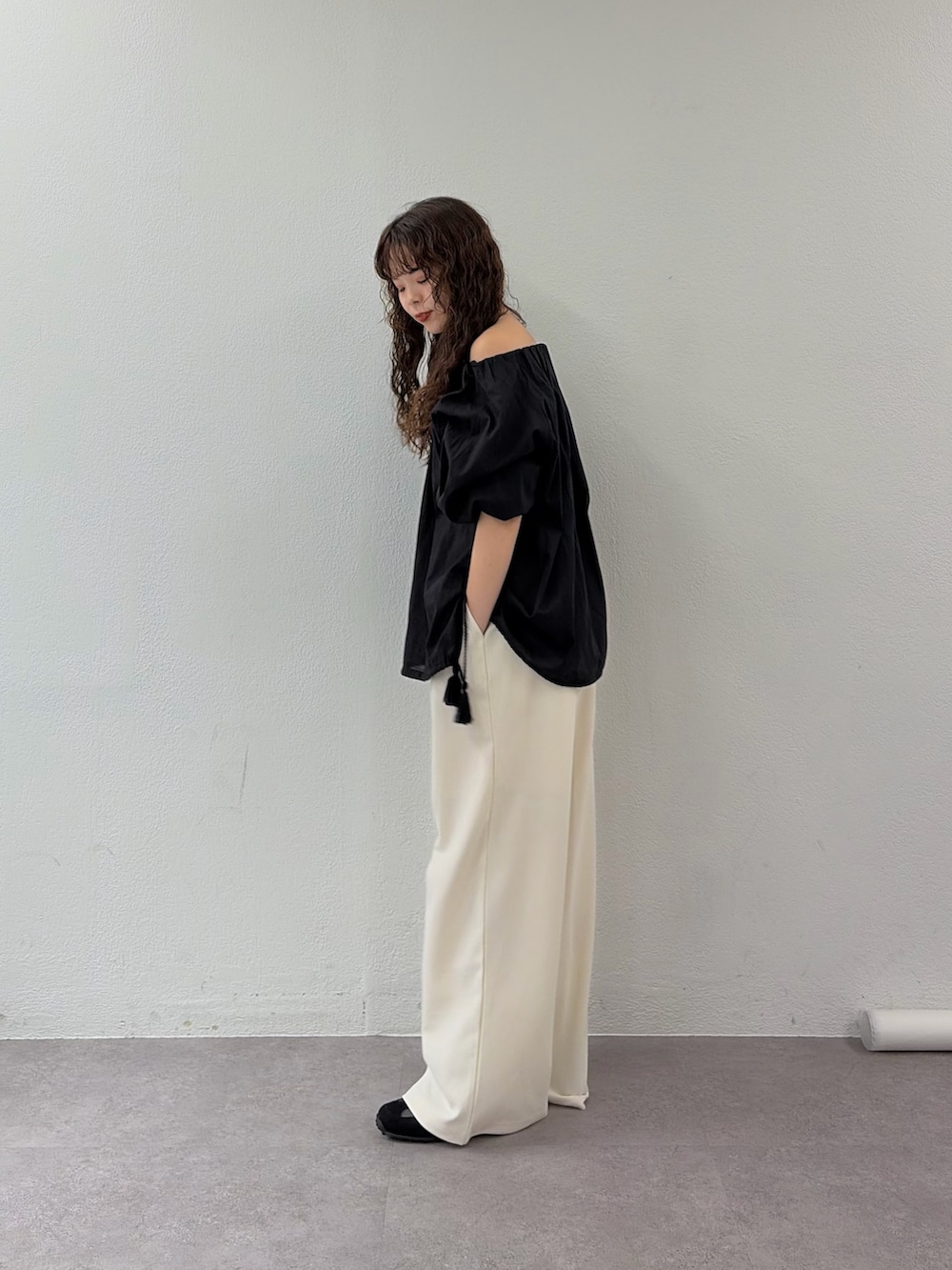 ブラック系のシャツ/ブラウス、ホワイト系のスラックス、ブラック系のスニーカーを着用したレディースの春コーディネートの2枚目の写真