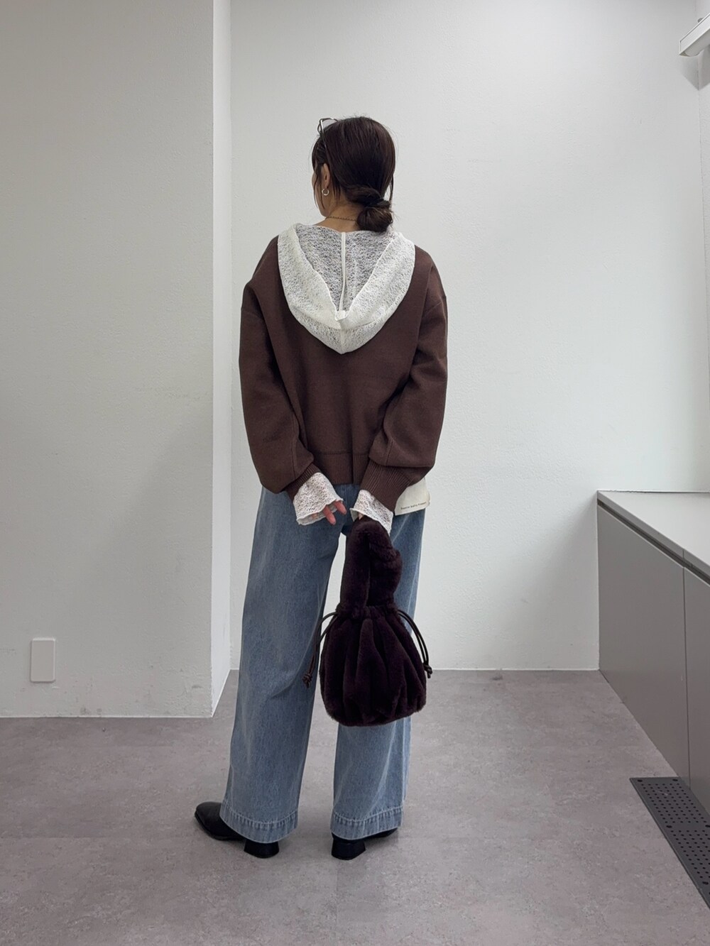 ブラウン系のニット/セーター、ブルー系のデニムパンツ、ブラック系のブーツを着用したレディースの冬コーディネートの3枚目の写真