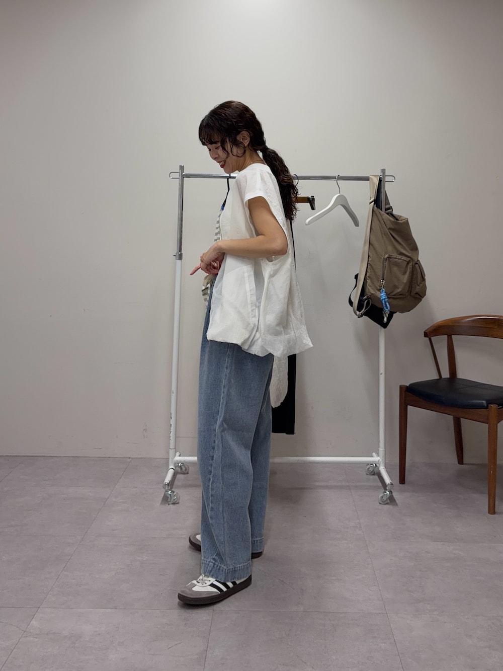 ホワイト系のブルゾン、ブルー系のデニムパンツを着用したレディースの春コーディネートの2枚目の写真