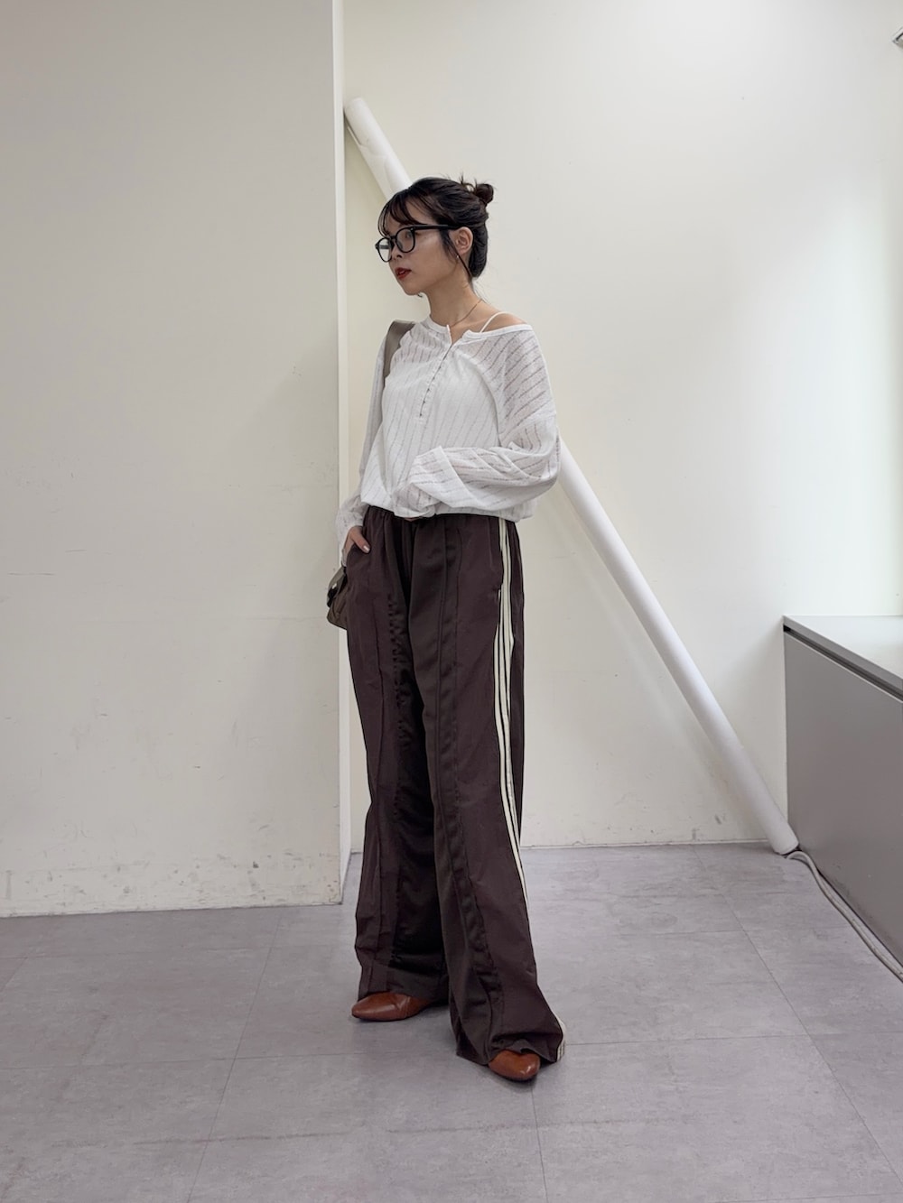 ホワイト系のTシャツ/カットソー、ブラウン系のスウェットパンツ、ブラウン系のパンプスを着用したレディースの冬コーディネートの2枚目の写真