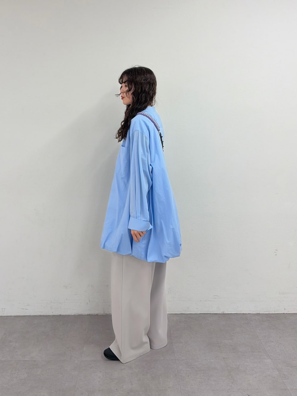 ブルー系のシャツ/ブラウス、グレー系のスラックス、グレー系のショルダーバッグを着用したレディースの春コーディネートの2枚目の写真