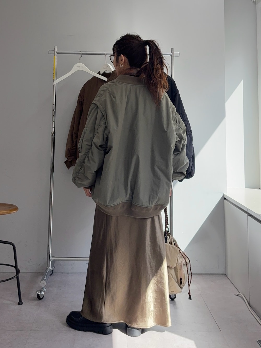 オレンジ系のシャツ/ブラウス、グリーン系のスカート、グリーン系のMA-1を着用したレディースの秋コーディネートの3枚目の写真