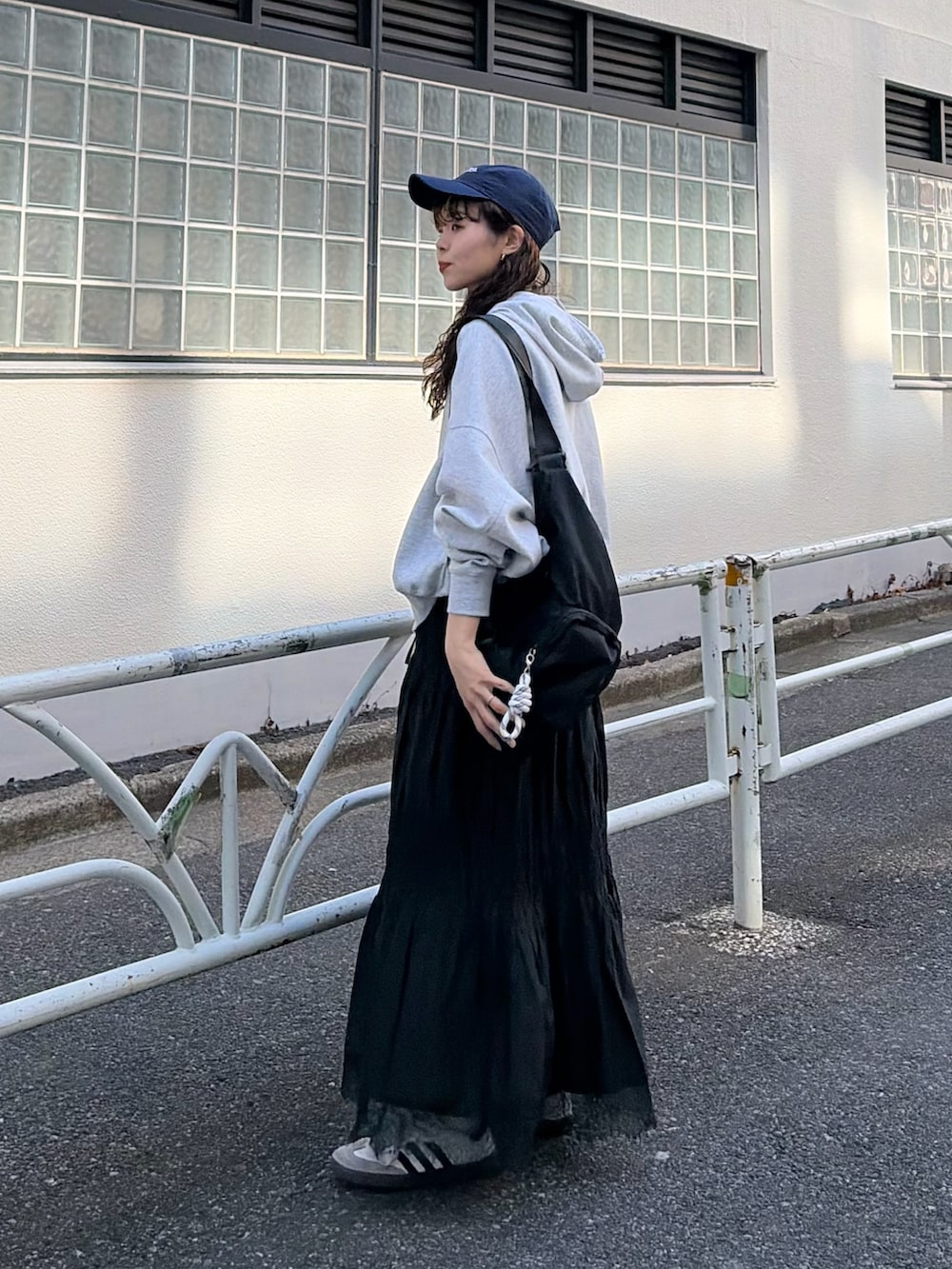 グレー系のパーカー、ホワイト系のスカートを着用したレディースの春コーディネートの3枚目の写真