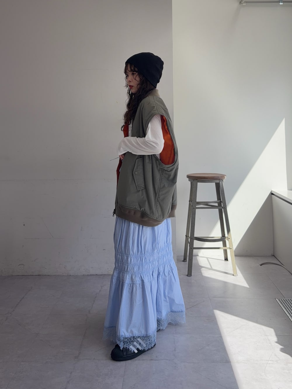 グリーン系のMA-1、ホワイト系のTシャツ/カットソー、ブルー系のスカートを着用したレディースの春コーディネートの2枚目の写真