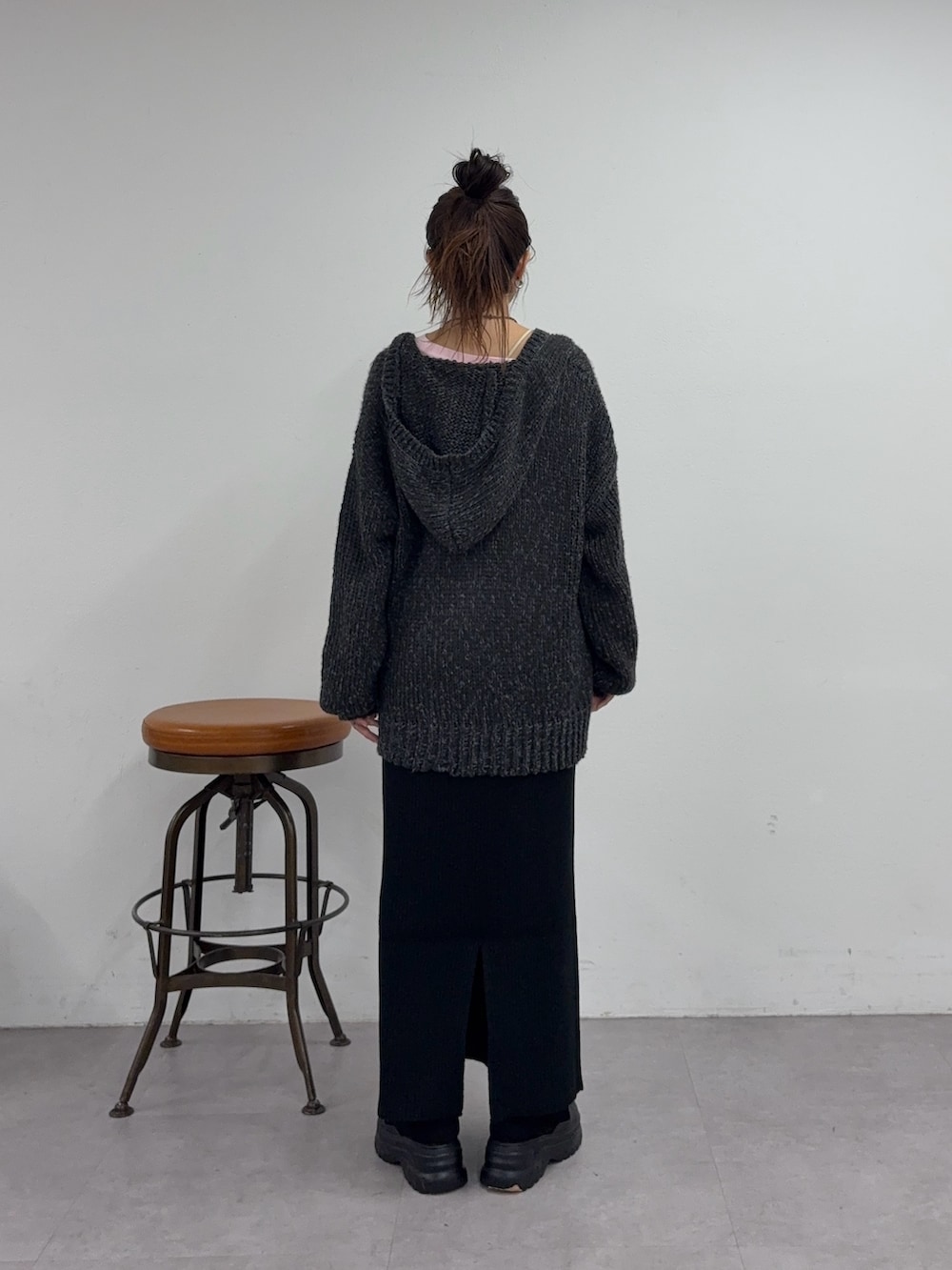 ブラック系のスカート、ブラック系のスニーカー、グレー系のニット/セーターを着用したレディースの秋コーディネートの3枚目の写真