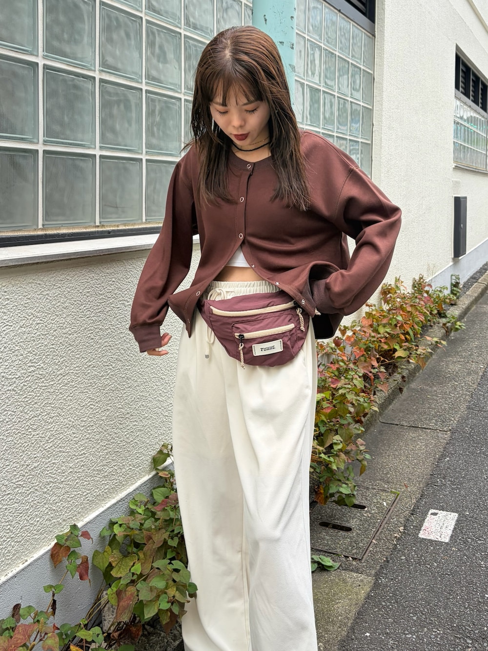 ブラウン系のカーディガン/ボレロ、ホワイト系のスラックス、レッド系のボディバッグ/ウエストポーチを着用したレディースの秋コーディネートの4枚目の写真