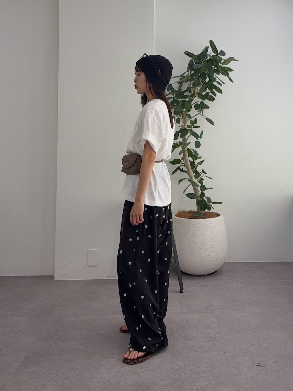 ホワイト系のTシャツ/カットソー、ブラック系のスラックス、ベージュ系のボディバッグ/ウエストポーチを着用したレディースの夏コーディネートの2枚目の写真