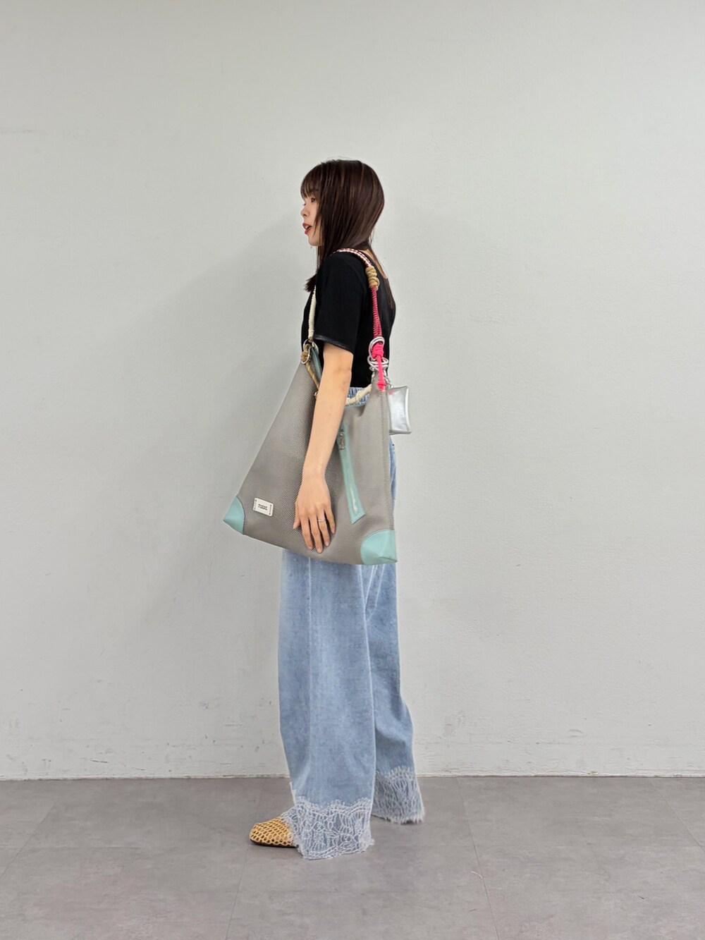 ブラック系のTシャツ/カットソー、ブルー系のデニムパンツ、ベージュ系のパンプスを着用したレディースの春コーディネートの2枚目の写真