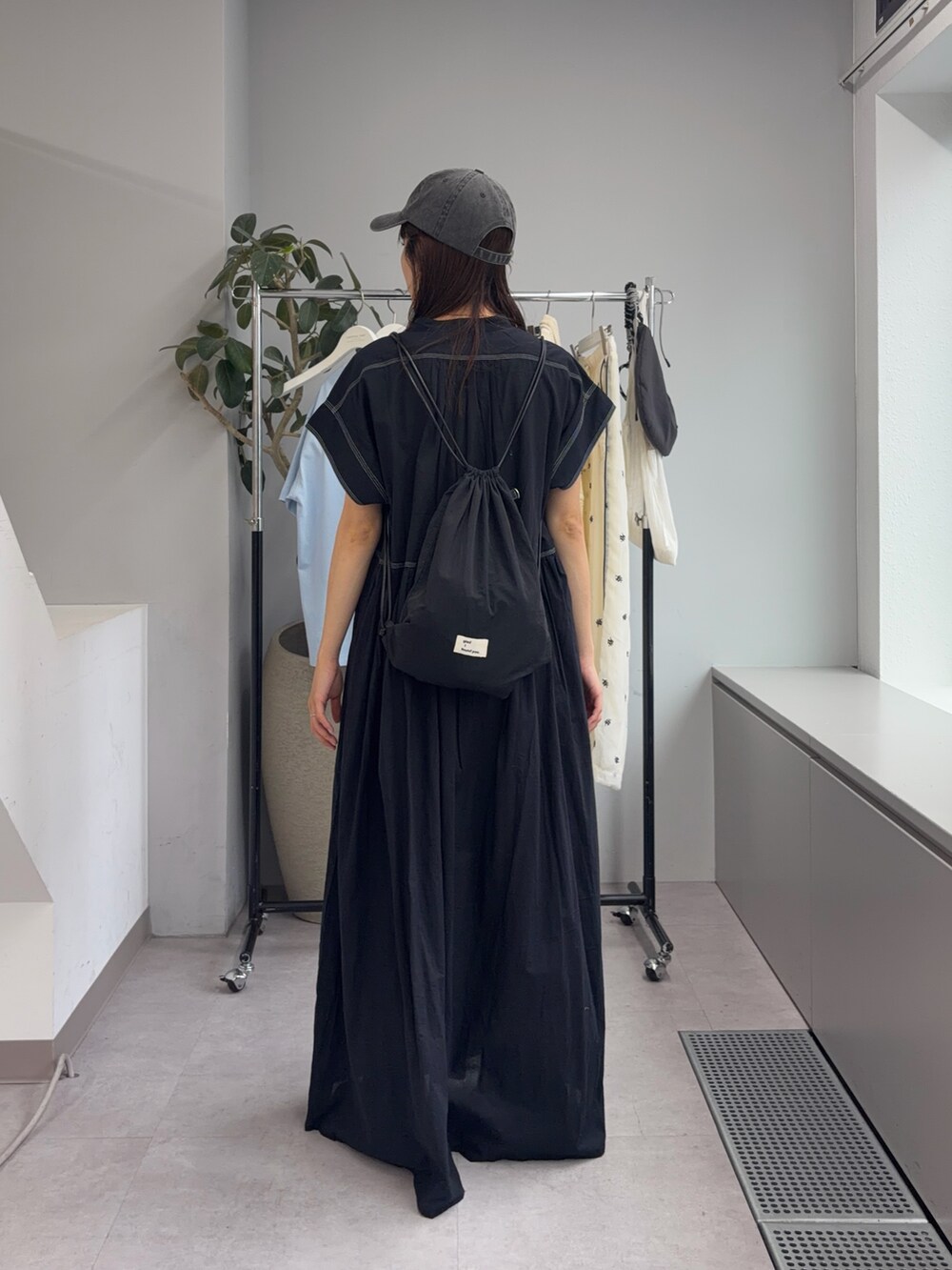 ブラック系のワンピース、グレー系のキャップを着用したレディースの夏コーディネートの3枚目の写真