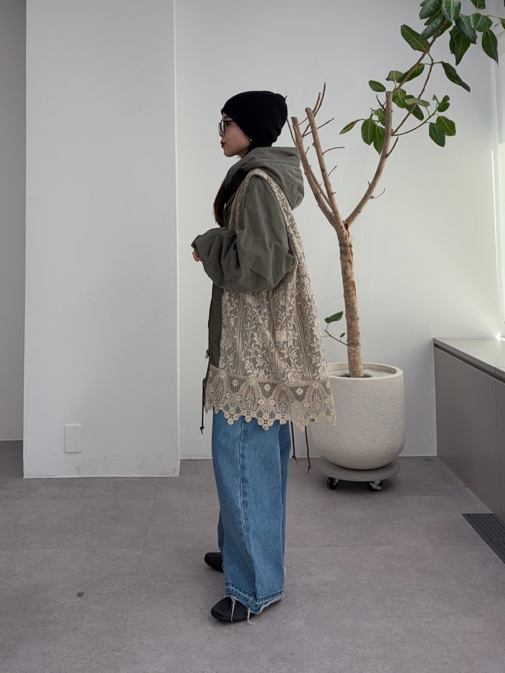 グリーン系のその他アウター、ブルー系のデニムパンツ、ブラック系のパンプスを着用したレディースの冬コーディネートの2枚目の写真