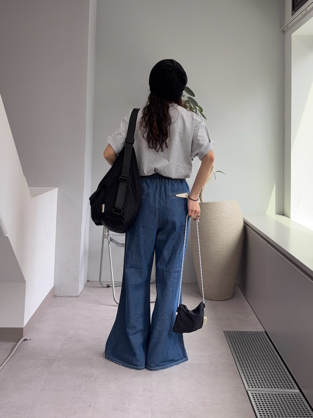 グレー系のTシャツ/カットソー、ブルー系のデニムパンツ、ブラック系のパンプスを着用したレディースの春コーディネートの3枚目の写真