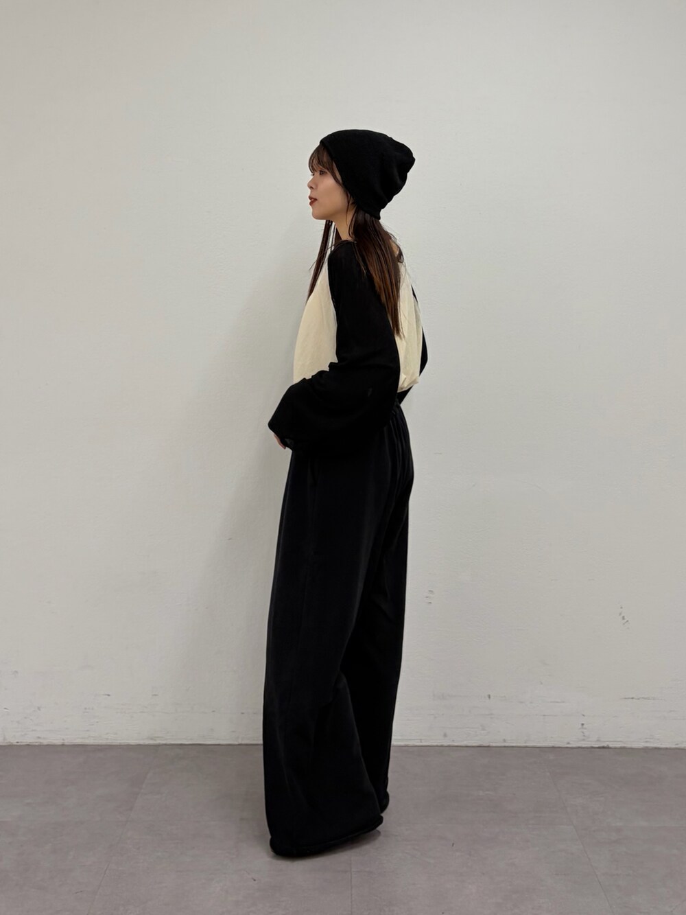 ホワイト系のTシャツ/カットソー、ブラック系のスウェットパンツ、ブラウン系のパンプスを着用したレディースの冬コーディネートの2枚目の写真