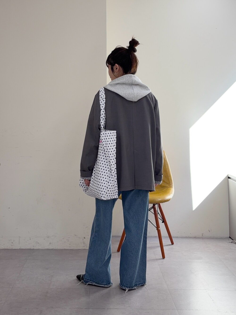 グレー系のパーカー、ブルー系のデニムパンツ、ブラック系のパンプスを着用したレディースの冬コーディネートの3枚目の写真