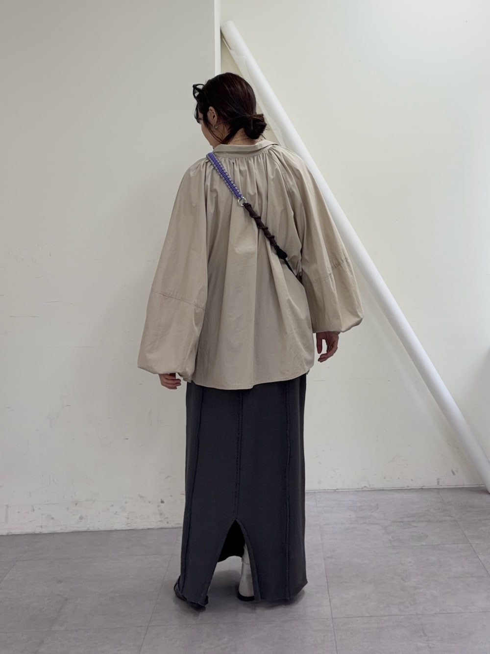 ベージュ系のシャツ/ブラウス、グレー系のスカート、ブラック系のパンプスを着用したレディースの冬コーディネートの3枚目の写真