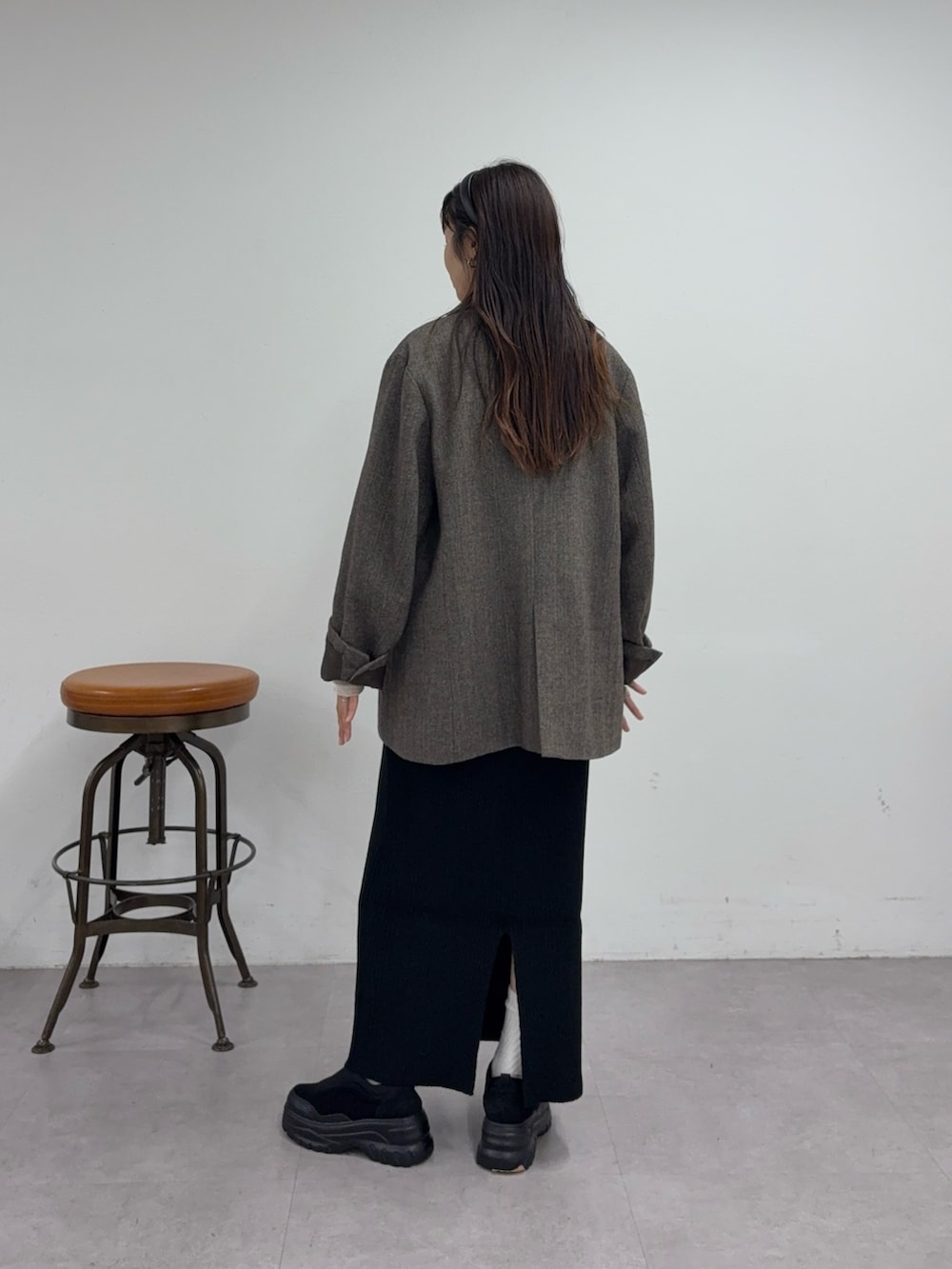 ホワイト系のTシャツ/カットソー、ブラウン系のテーラードジャケット、ブラック系のスカートを着用したレディースの秋コーディネートの3枚目の写真