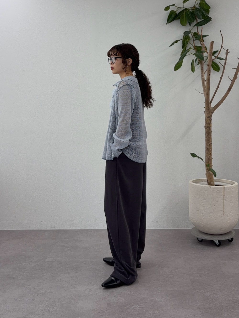 ブルー系のシャツ/ブラウス、グレー系のつなぎ/オールインワン、ブラック系のパンプスを着用したレディースの春コーディネートの2枚目の写真