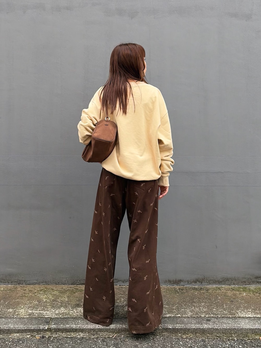 ベージュ系のスウェット、ブラウン系のTシャツ/カットソー、ブラック系のブーツを着用したレディースの秋コーディネートの4枚目の写真