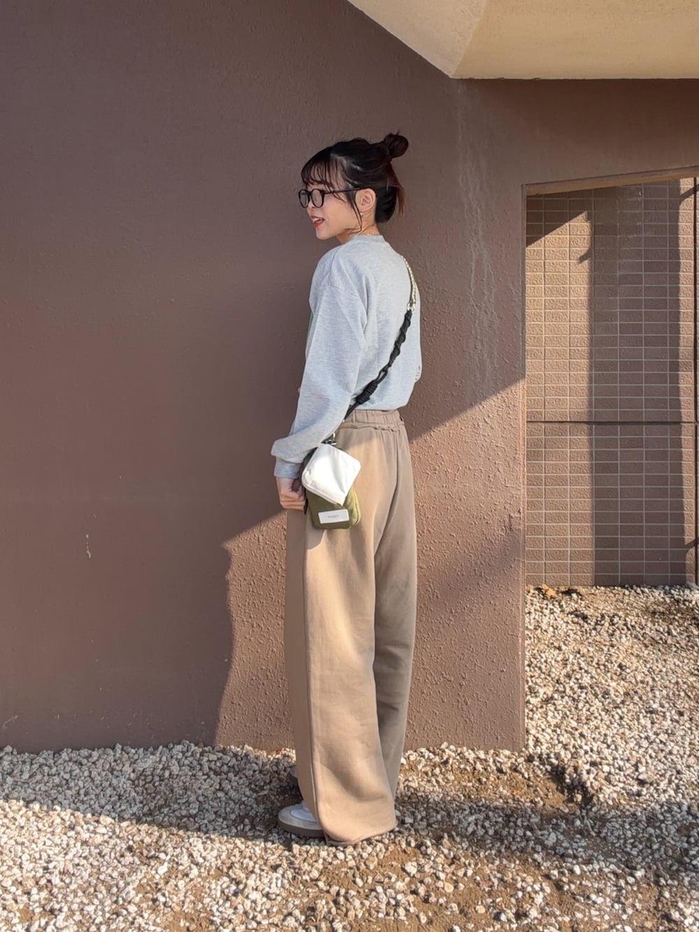 グレー系のTシャツ/カットソー、ベージュ系のスウェットパンツを着用したレディースの冬コーディネートの2枚目の写真