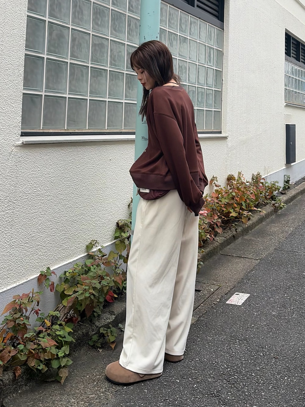 ブラウン系のカーディガン/ボレロ、ホワイト系のスラックス、レッド系のボディバッグ/ウエストポーチを着用したレディースの秋コーディネートの2枚目の写真