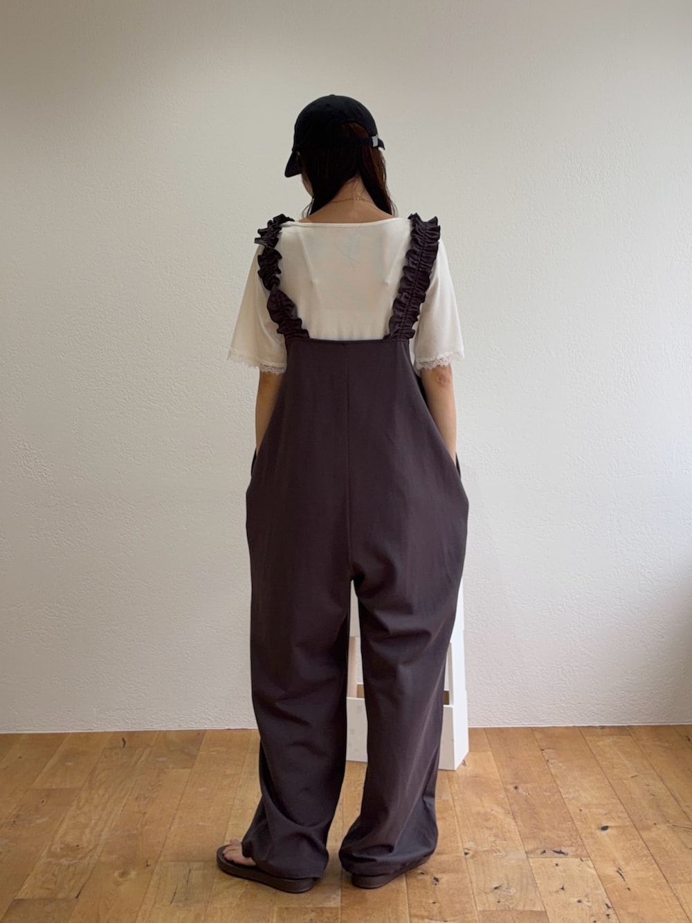 グレー系のつなぎ/オールインワン、ホワイト系のTシャツ/カットソー、ブラック系のキャップを着用したレディースの夏コーディネートの2枚目の写真
