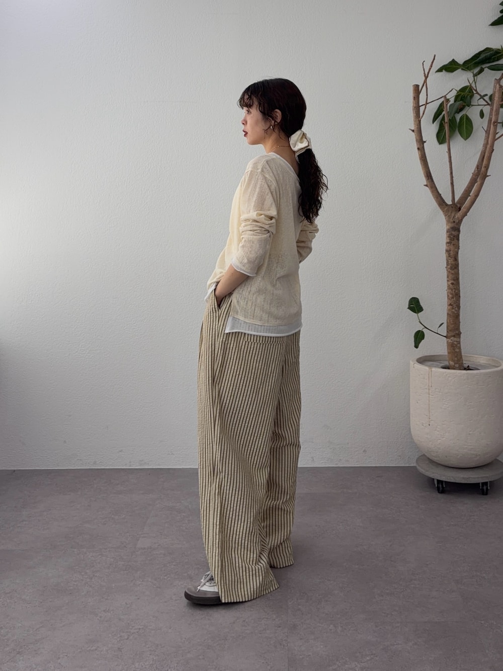 イエロー系のカーディガン/ボレロ、ベージュ系のその他パンツ、ホワイト系のシュシュを着用したレディースの春コーディネートの2枚目の写真