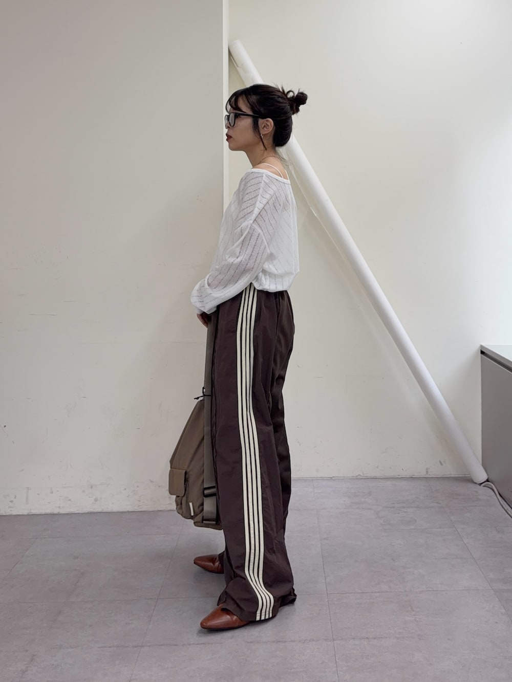 ホワイト系のTシャツ/カットソー、ブラウン系のスウェットパンツ、ブラウン系のパンプスを着用したレディースの冬コーディネートの3枚目の写真